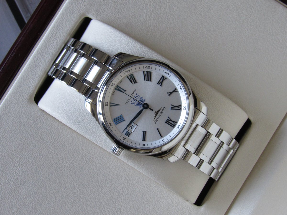 El reloj completo apoyado sobre la bandeja clara de su estuche.