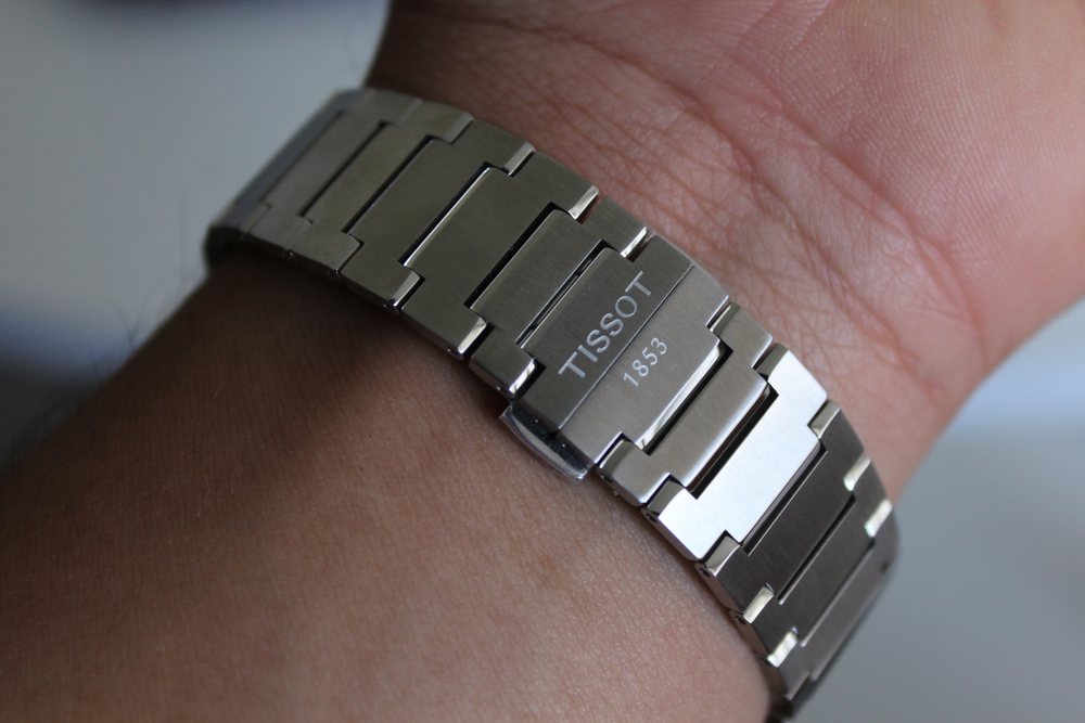 Detalle del broche del brazalete de acero, grabado con la marca del reloj.